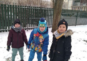 Chłopcy stoją obok wielkiej śnieżnej kuli